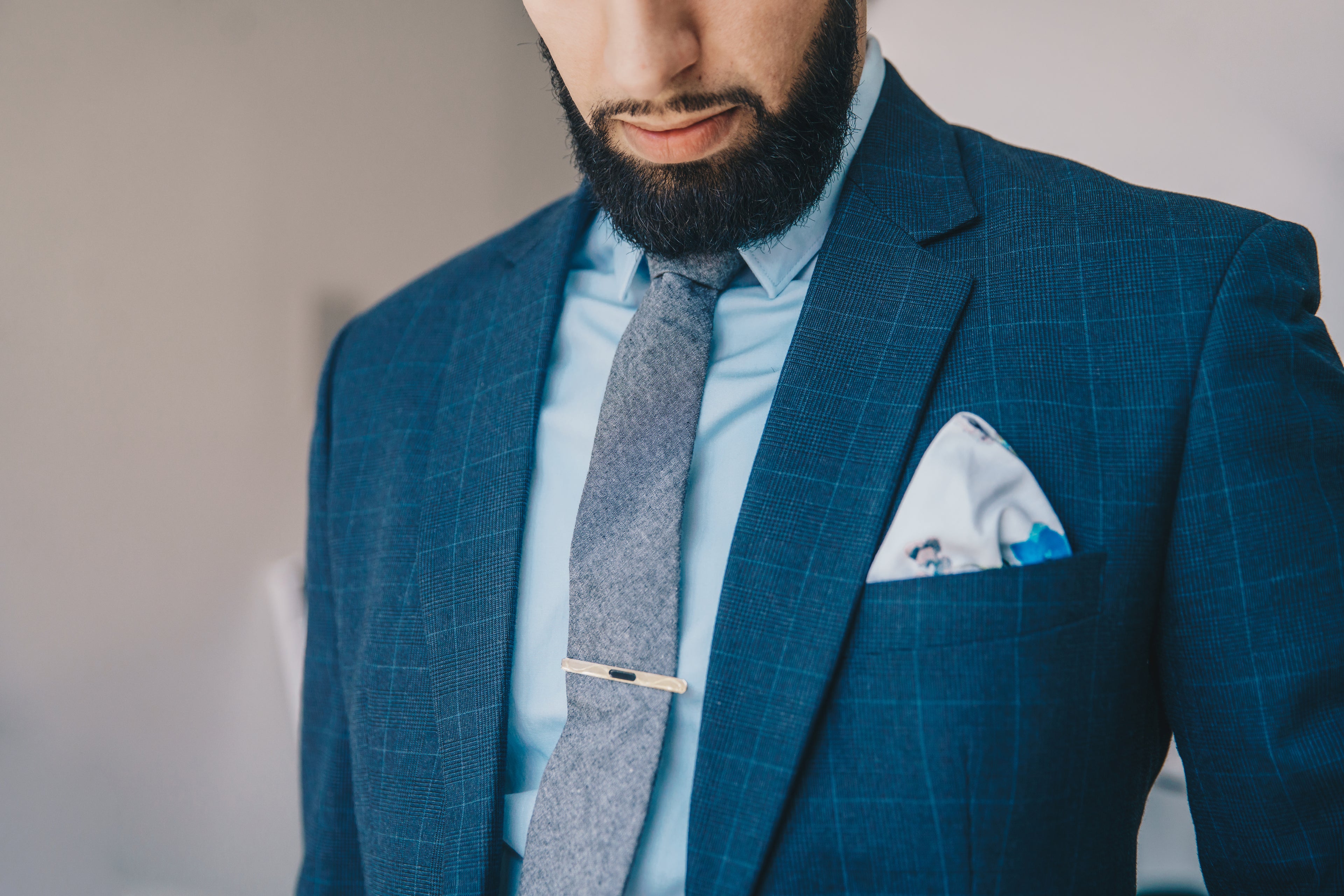 man in bespoke suit and tie with pocket square, tie clip and beard