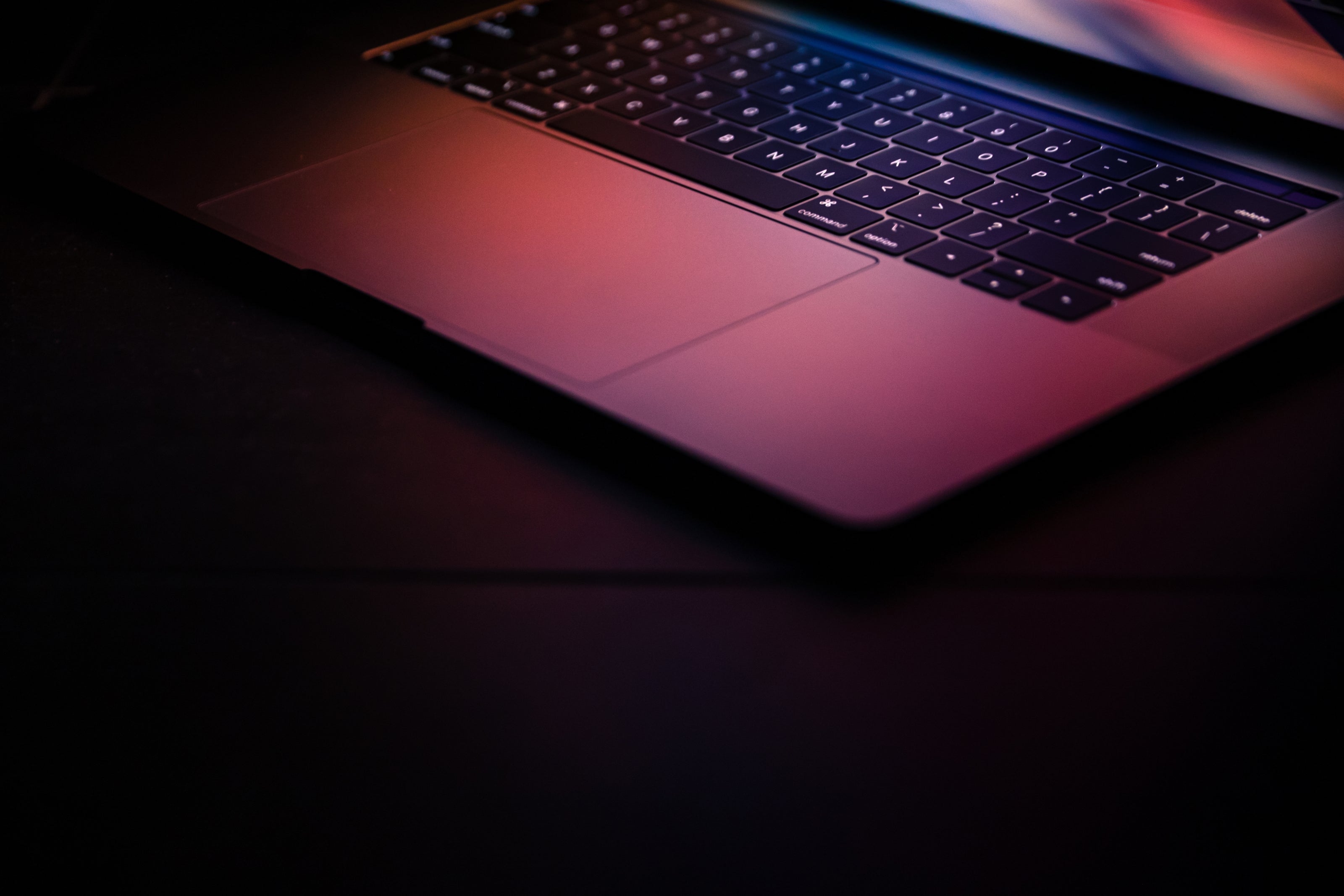 illuminating laptop with keyboard and lit screen in dark seting 